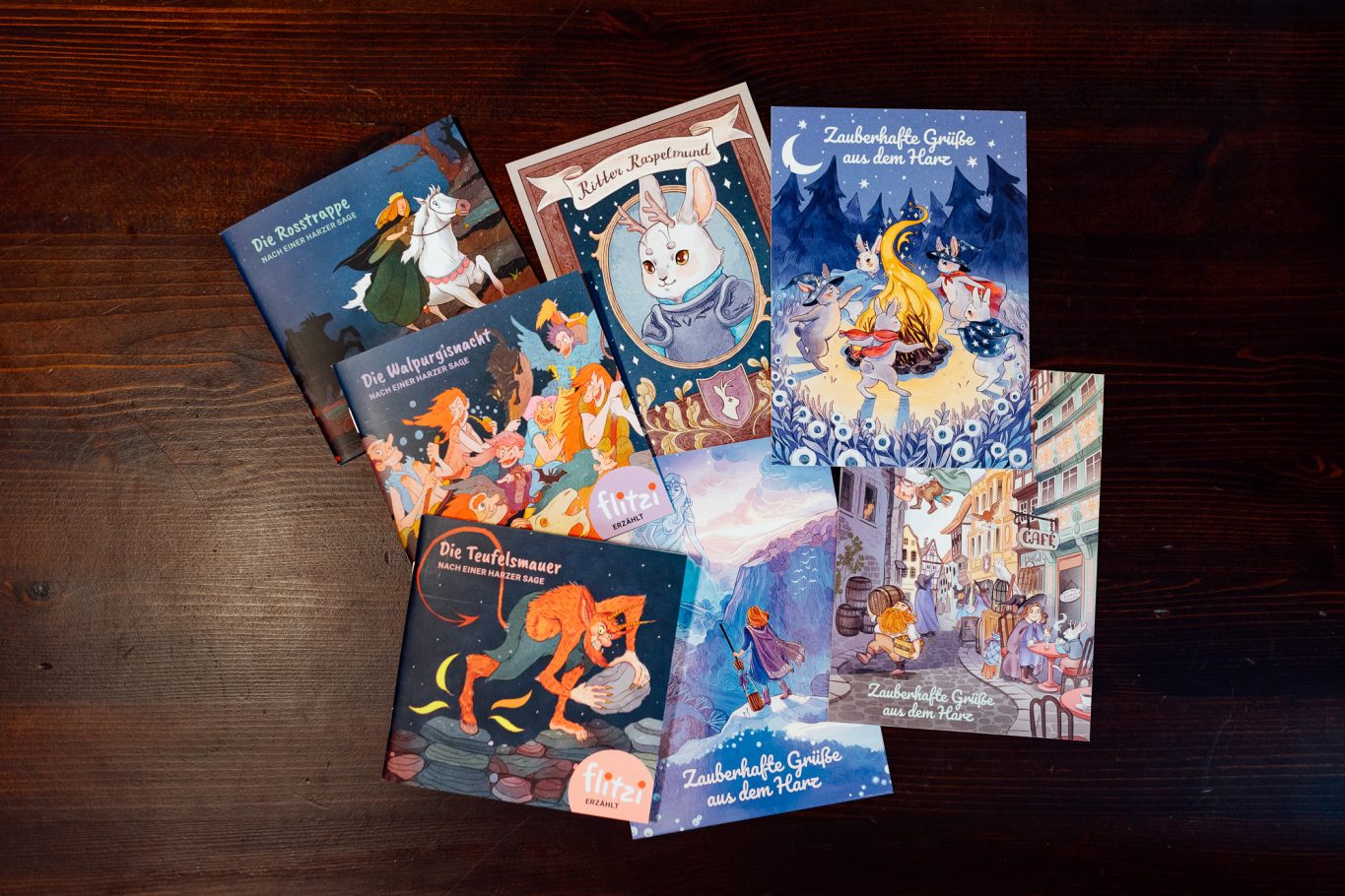 Souvenirs aus dem Harz Eine Sammlung von bunten Kinderbuch-Covern auf einem Holztisch.
